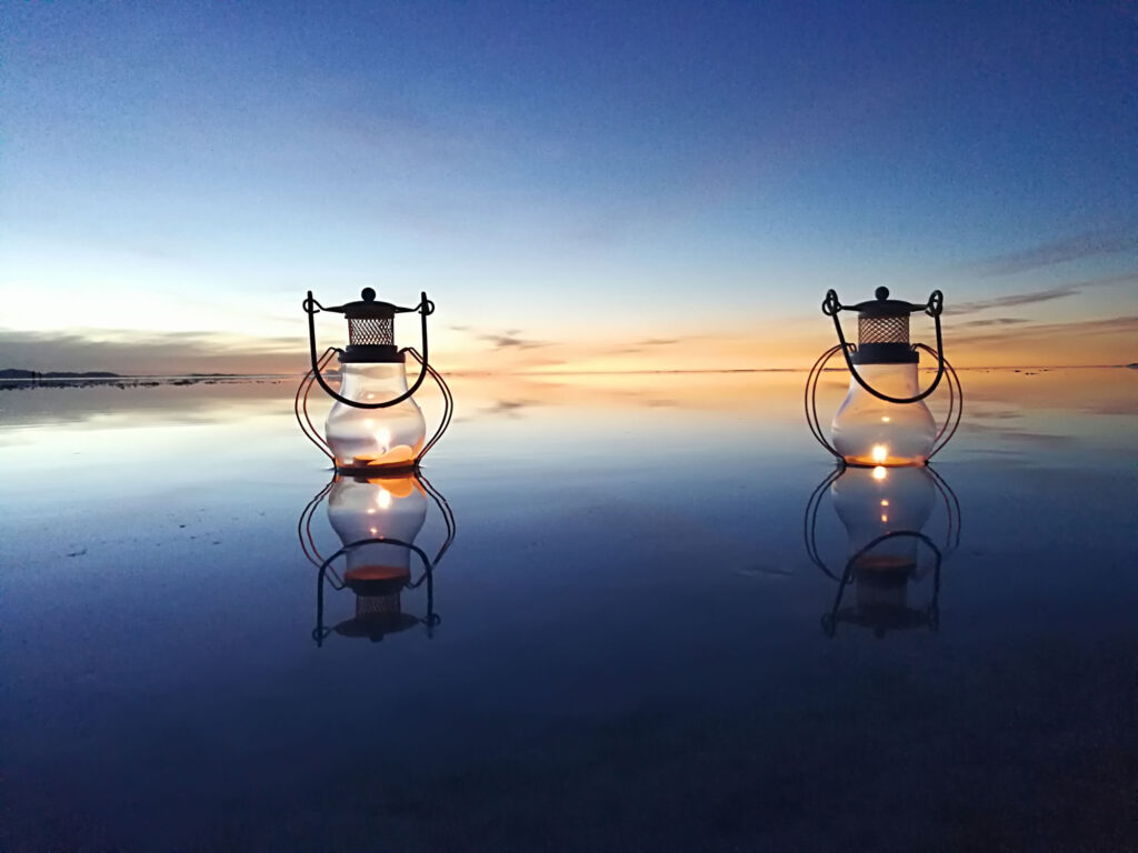 Foto tomada desde del salar en un atardecer mostrando dos linternas una toma muy bella