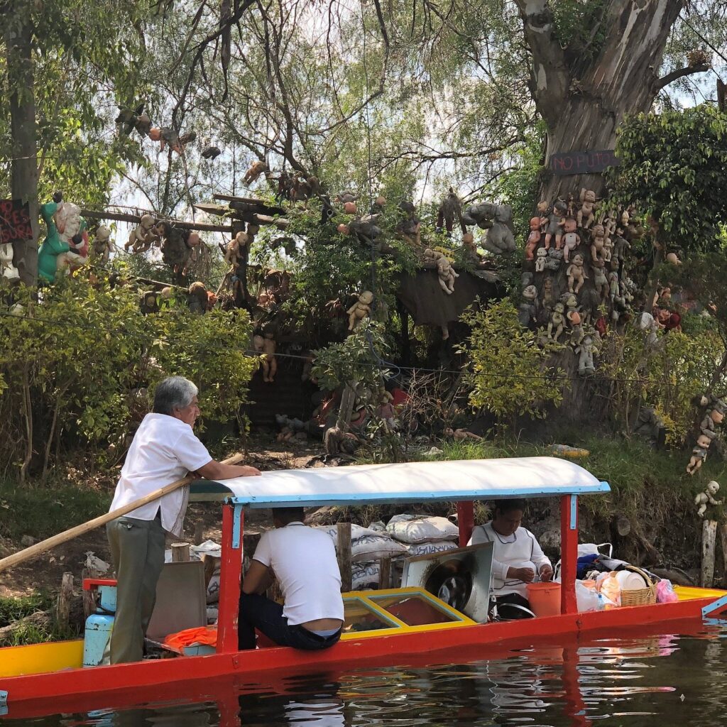 Foto real de los pequeños botes que circulan por el canal que costea a la isla
